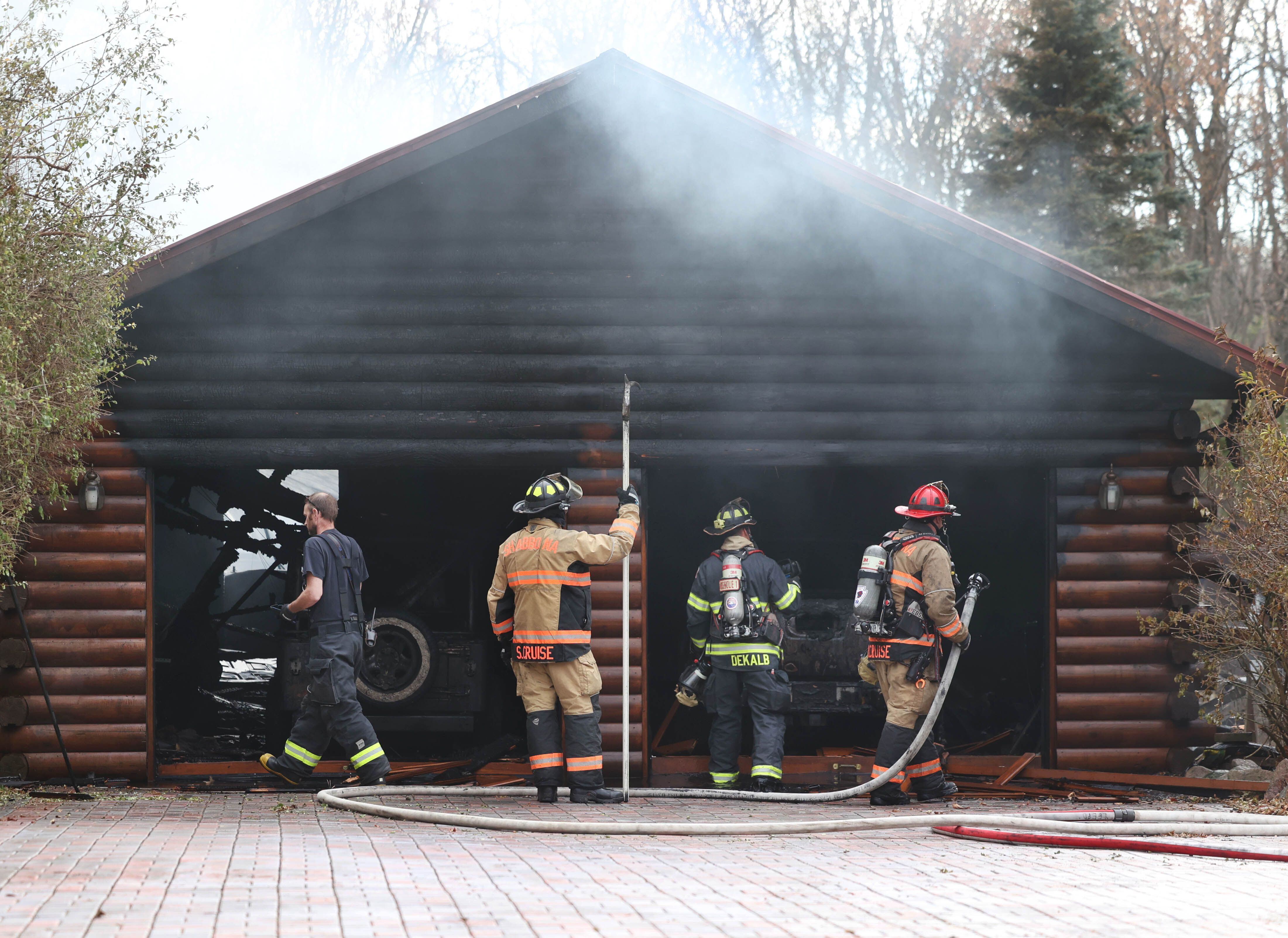 Firefighters work inside the garage of a house that was destroyed by fire Thursday, Nov. 13, 2025, near Shabbona Grove Road in Shabbona. Several local departments responded to the general alarm structure fire.
