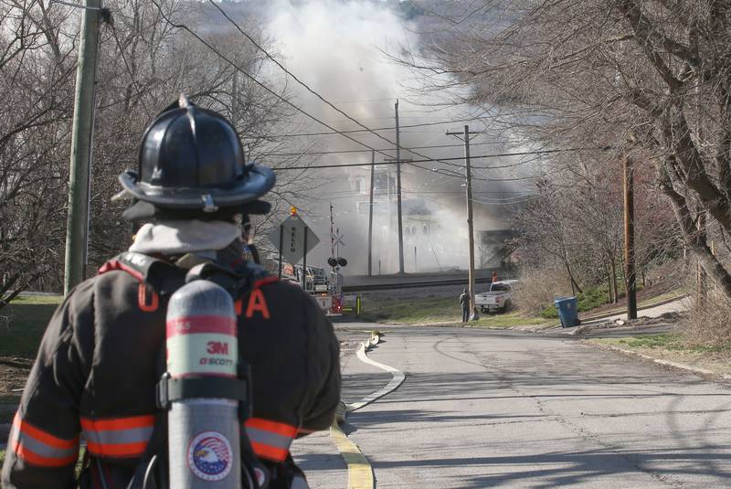 Ottawa firefighter Caleb Beck observes the fire scene on top of the hill of Pine Street looking at the heavy smoke at the former Platform 31 tavern on Monday, March 24, 2025 on Water Street in Peru. The fire was upgraded to a three-alarm summing ire departments from La Salle, Utica, Mendota, Tonica, Ottawa, Ladd, Spring Valley, Lostant, Cedar Point, Troy Grove and Peru responded to the fire.