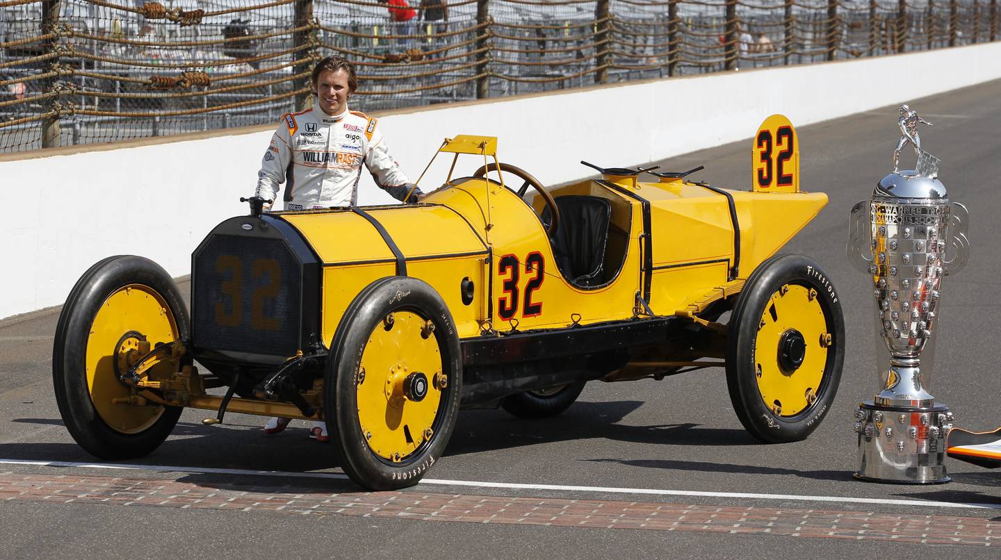 IndyCar driver Dan Wheldon, of England, poses with the Borg-Warner Trophy in front of the Marmon Wasp, the car that won the first race in 1911, during the traditional winner's photo of the Indianapolis 500 auto race champion on the start/finish line at the Indianapolis Motor Speedway in Indianapolis, May 30, 2011.