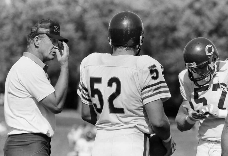 Chicago Bears offensive coordinator Ed Hughes chats with linebacker Cliff Thrift and offensive lineman Tom Thayer during training camp on Wednesday, June 12, 1985 in Platteville Wis.