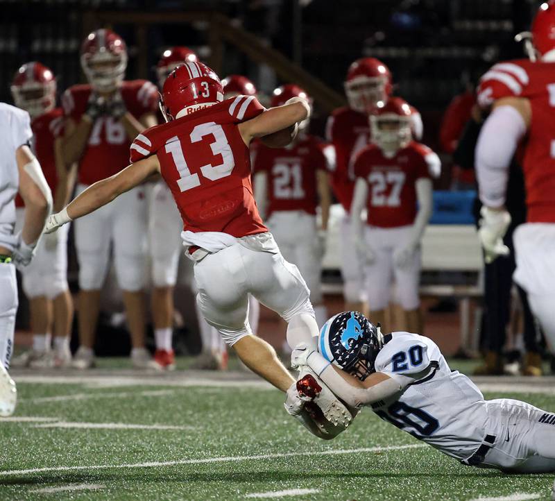 Downers Grove South's Coen Godenschwager (20) wraps up Naperville Central's  Aiden Clark Friday October 27, 2023 in Naperville.