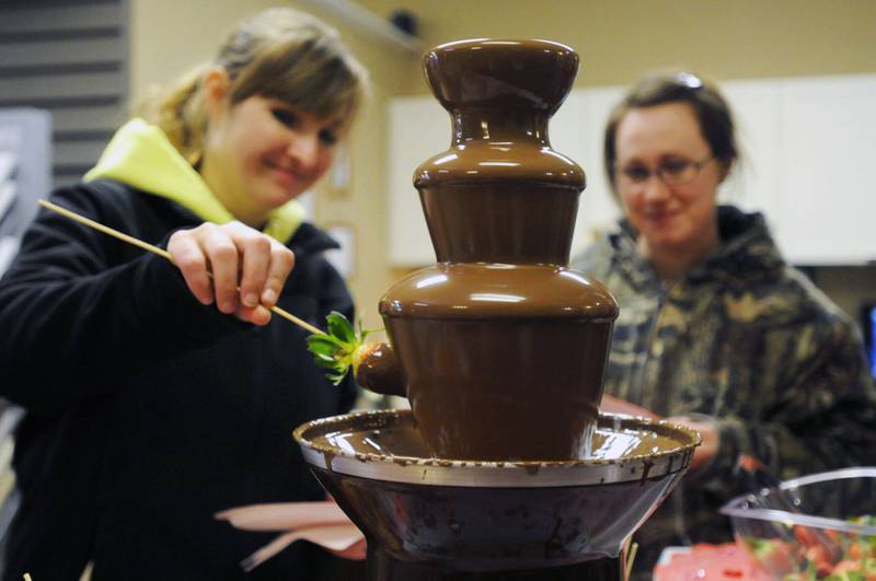Two attendees dip strawberries in a chocolate fountain during the village of Bourbonnais’ second annual Chocolate Tour in 2018. The event returns in February and registration is open through Dec. 13 for businesses to sign up to be a tour stop.