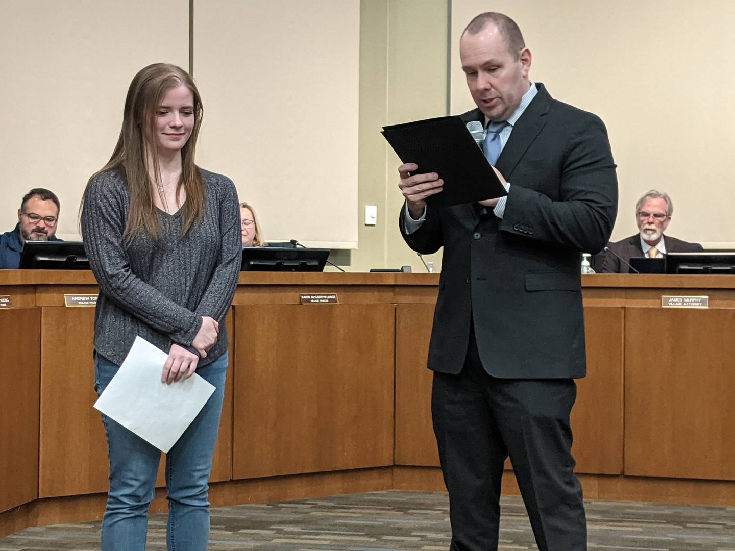 Oswego Village President Ryan Kauffman, right, reads a proclamation honoring Oswego resident Valerie Anderson, left, for being the winner of the Oswego250 Logo Contest during the Tuesday, Feb. 3, 2026 Oswego Village Board meeting.