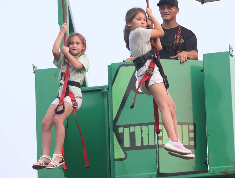 Jojo Kiersnowski and Addison Jagele, both of Peru, zip line during the The Taste of the Illinois Valley on Friday, Aug. 1, 2025 at Centennial Park in Peru. The event featured food vendors, live music, a beer tent and a kids zone, Dreamwave wrestling and Pandora's Box, a Aerosmith tribute band.