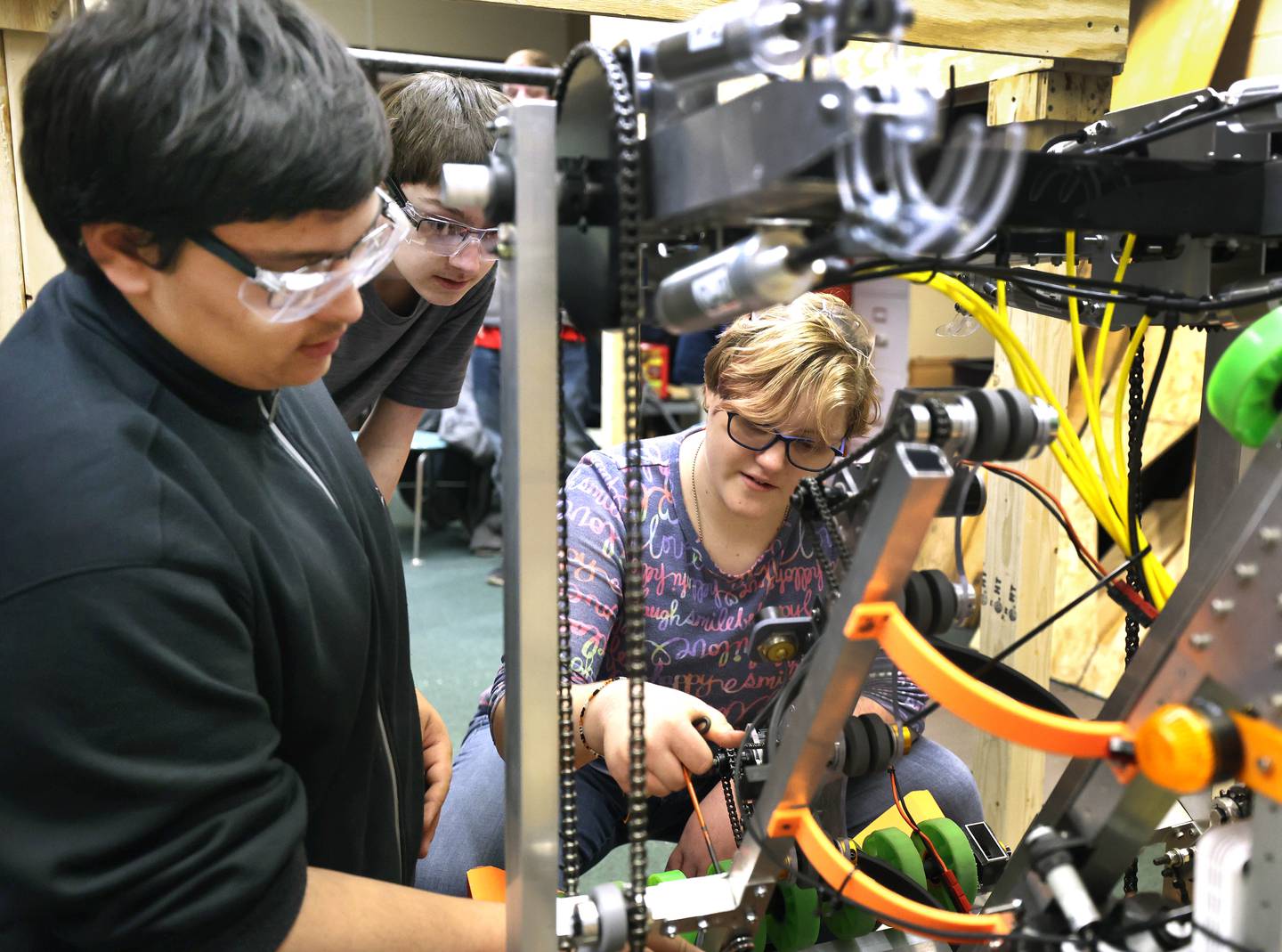 Members of the DeKalb High School "Crowbotics" team, freshman Lawrence Zanazaro, (left) freshman Blake Bollow and  freshman Felicia Kapity work on their robot Thursday, March 10, 2022, at Huntley Middle School in DeKalb. The team is preparing for a competition that begins in early April.