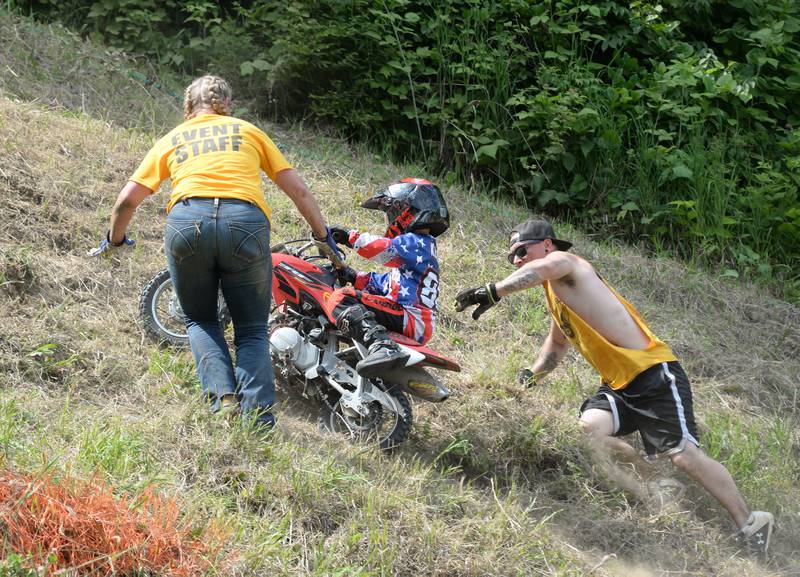 Hillclimb staff help Kaeden Greenham, 6, of Morrison, at the end of one of his runs in the kids' division at the Rock River Riders Motorcycle Club's Father's Day Hillclimb on Sunday, June 15, 2025.