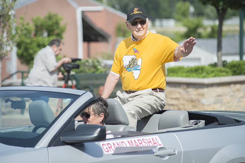 Dixon Memorial parade grand Marshal Bill Reigle waves from his ride Monday, May 30, 2022.