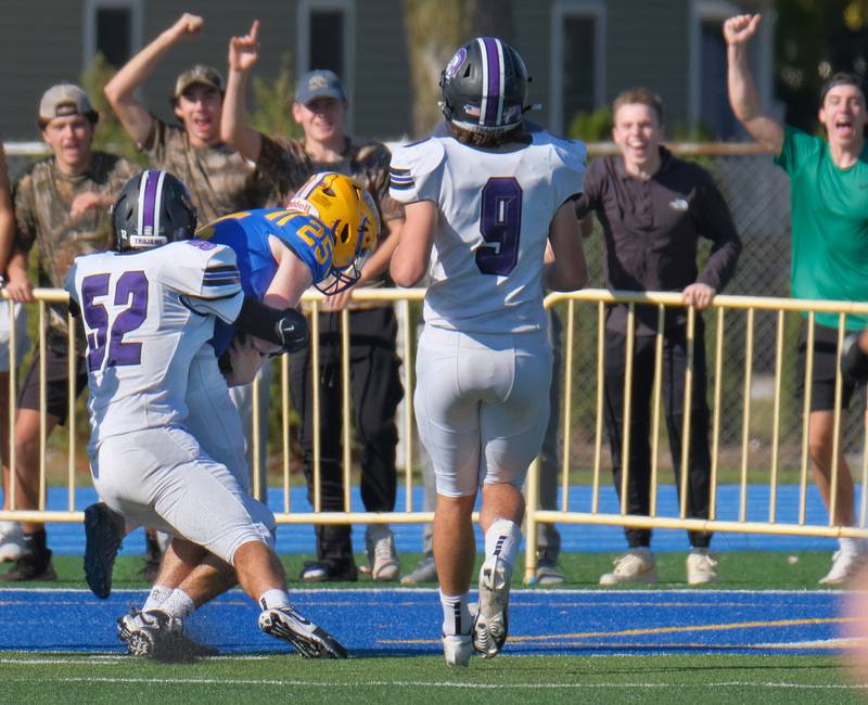 Lyons Township's Patrick Cramer (25) scores a touchdown after blocking a punt as Downers Grove North's Alexander Kartsounes (52) tries to stop him during a game on Oct. 22, 2022 at Lyons Township High School in LaGrange.