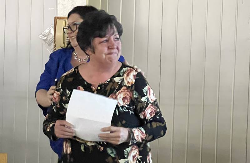 Carolyn Tobinson, the daughter of Dave Tobinson, looks at a powerpoint slide with her name on it after she was announced as the winner of Genoa Chamber of Commerce's 2022 Dave Tobinson, Outstanding Member of the Year Award on Feb. 15, 2023.