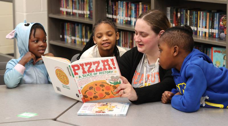 Mitchell Elementary School first grade teacher Cassandra Sprankle reads a book to some of her students Thursday, March 19, 2026, in the library at the school in DeKalb.