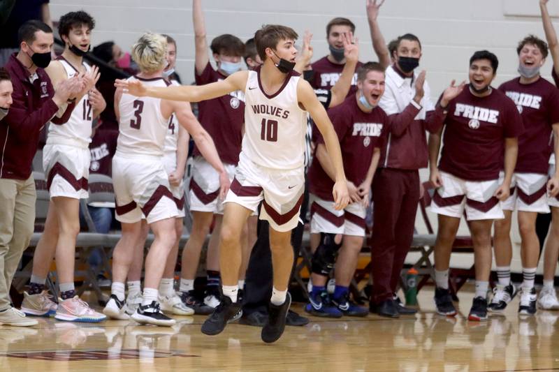 Prairie Ridge’s Cade Collins signals a third-quarter 3-point basket as the Wolves celebrate during boys varsity basketball action against Cary-Grove in Crystal Lake Tuesday night.