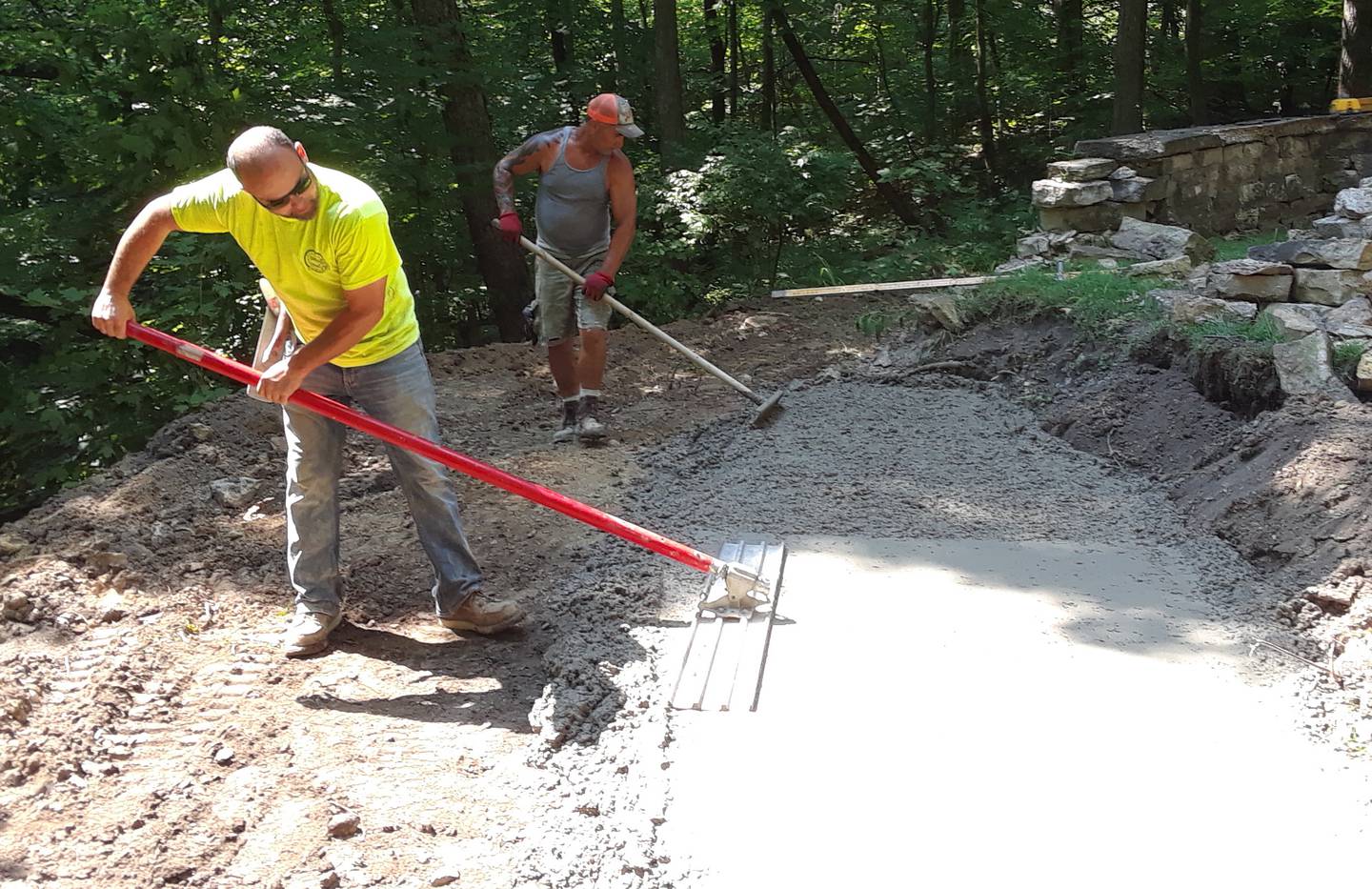John Anderson (green shirt) and Bobby Harden of Anderson Concrete finish the concrete footings on the southwest wall of the Wallace-Dickey Cemetery (not shown, Jade Gualandi of Western Sand and Gravel).