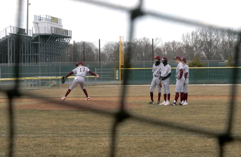 Infield players watch as Richmond-Burton relief pitcher Ryan Junge warms during a nonconference baseball game against Crystal Lake Central Friday, March 24, 2023, at Crystal Lake South High School.