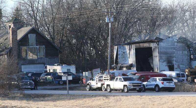 Smoke smolders from the roof of Harpers Used Cars and Towing on Tuesday, Jan. 25, 2025 in Sheridan. Here, the Illinois State Fire Marshal and La Salle County Sheiff deputies work the scene of the fire.