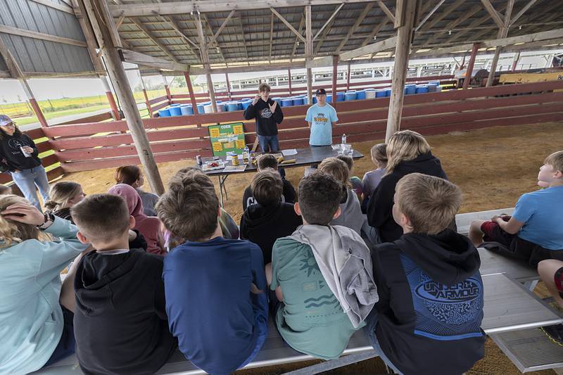 Amboy FFA students Tyler Mahar (left) and Bryden Boyer teach kids about uses of corn Friday, April 24, 2026, at the Lee County Fairgrounds.