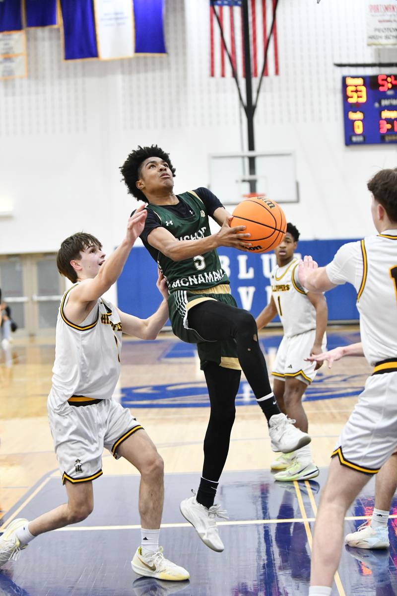 Bishop McNamara's Willie Felton floats to the hoop past Joliet Catholic Academy defenders during the Fightin' Irish's 79-67 victory over the Hilltoppers in the IHSA Class 2A Peotone Sectional semifinal on March 4, 2025.