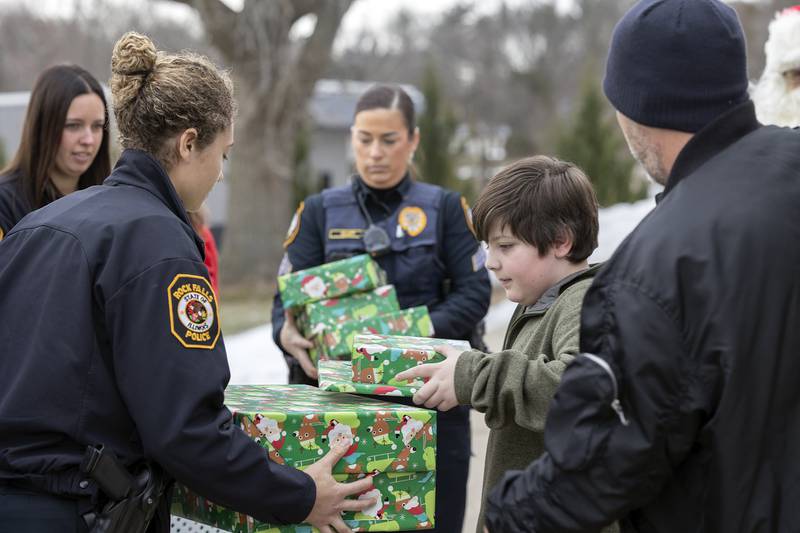 Parker, 10, helps carry in gifts Monday, Dec. 22, 2025, for Operation Santa.