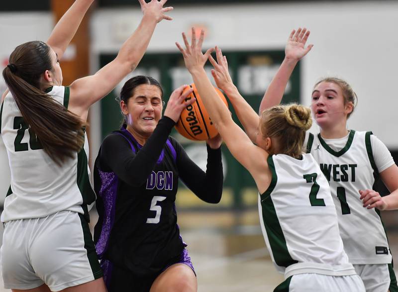 Downers Grove North’s Campbell Thulin (5) is swarmed by Glenbard West defenders during a game on December 4, 2025 at Glenbard West High School in Glen Ellyn.