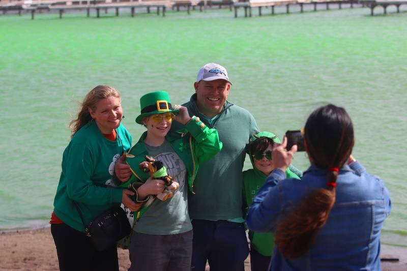 Will and Allison Koehler of Barrington have their picture made with children Charlotte, 11 and Landon, 8, near the bright green Fox River during the ShamROCKS the Fox Fest in McHenry on Saturday, March 15, 2025.