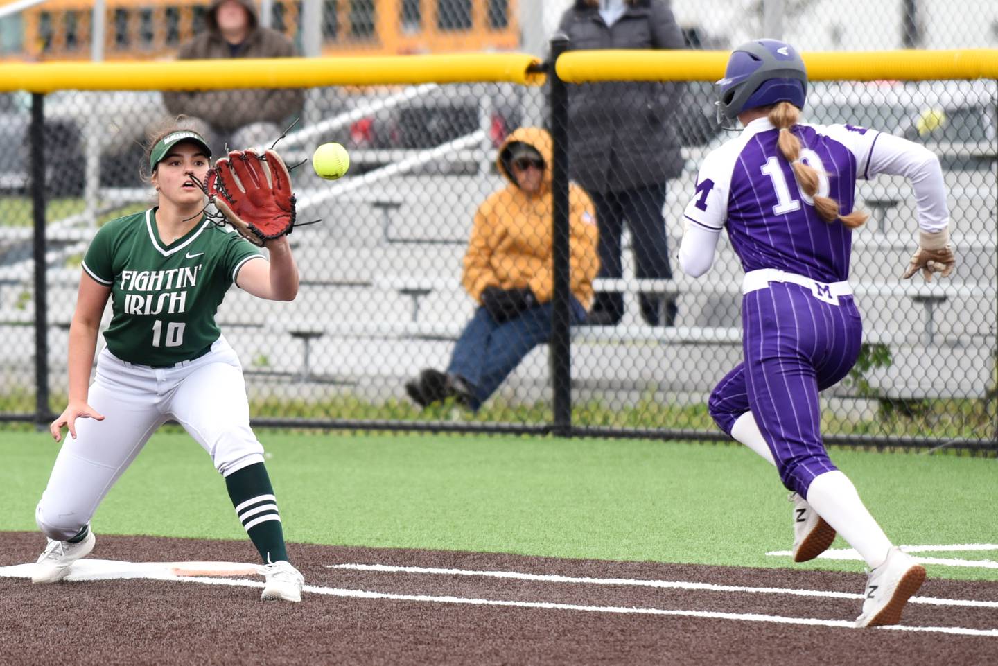 Bishop McNamara's Rhaya DePaolo, left, fields a throw at first base ahead of Manteno's Ayssa Singleton during the Class 2A Coal City Regional semifinals Wednesday, May 21, 2025.