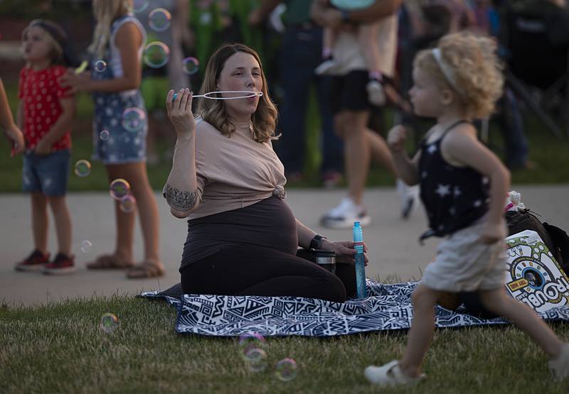 Ari, 3, chases after bubbles blown by Kayleigh Wolf Wednesday, July 3, 2024 at RB&W Park in Rock Falls for the Sterling/Rock Falls Jaycee’s fireworks show. Hundreds jammed the park to visit, listen to music and watch the display.