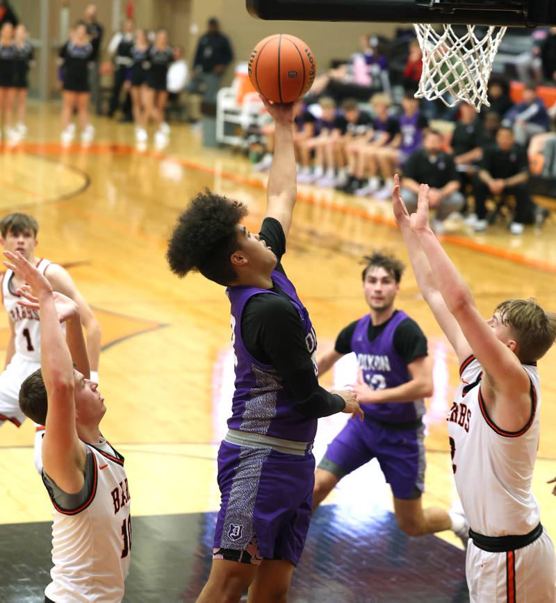 Dixon’s Darius Harrington shoots between two DeKalb defenders during their game Tuesday, Dec. 12, 2023, at DeKalb High School.