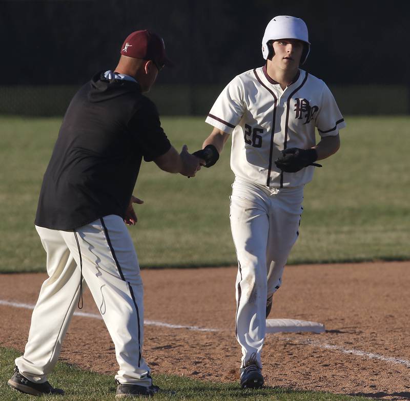 Prairie Ridge’s Tyler Vasey gets a high five from Prairie Ridge Head Coach Glen Pecoraro after Vasey hit a home run during a Fox Valley Conference baseball game against Huntley Wednesday, April 12, 2023, at Prairie Ridge High School.
