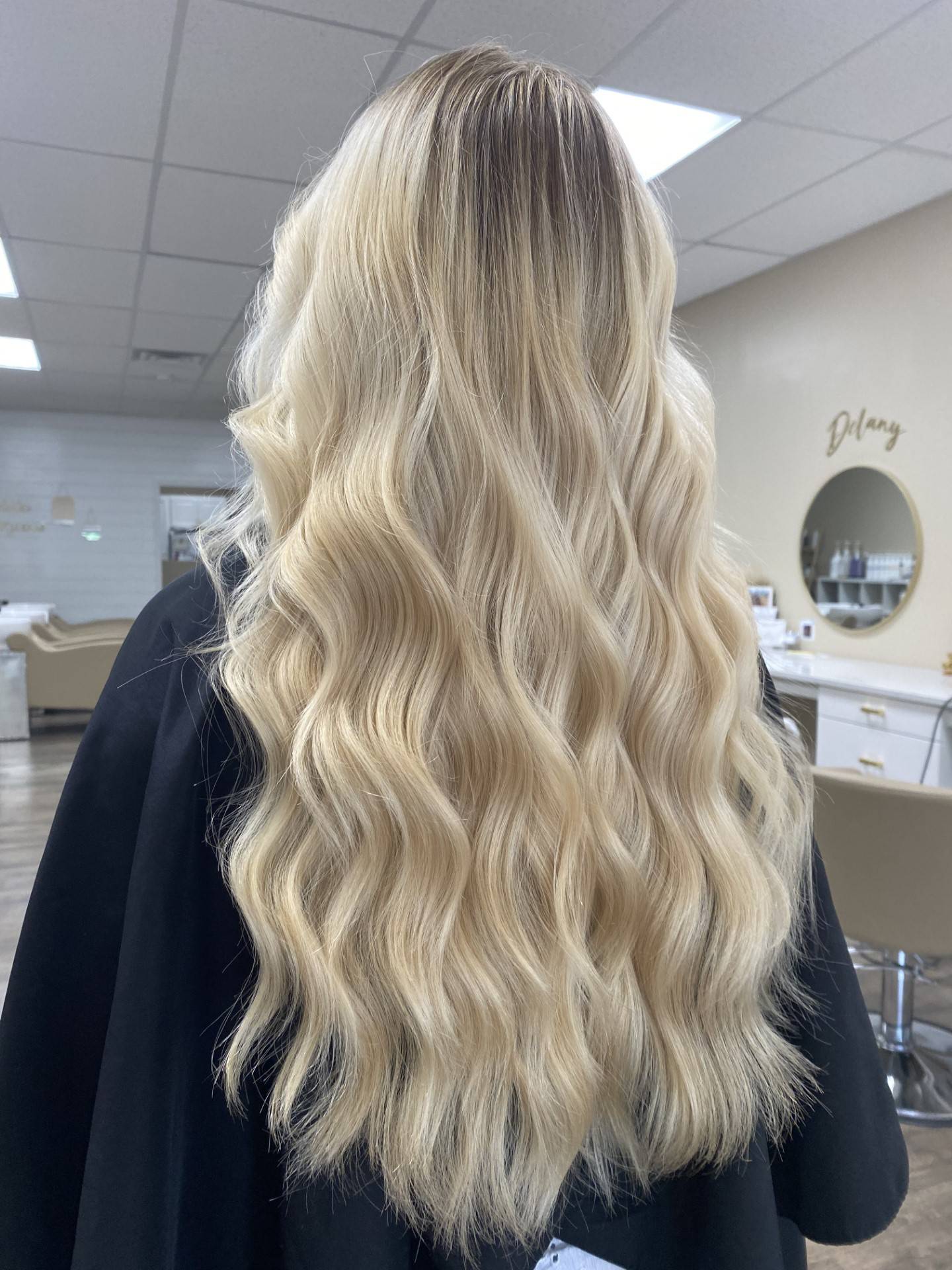 A client shows off her Barbie blonde hair at Champagne Joy Blow Dry Bar & Salon in Morris. Makiah Wilson, a hairstylist at the salon, said the salon is receiving a lot of calls for Barbie hair.