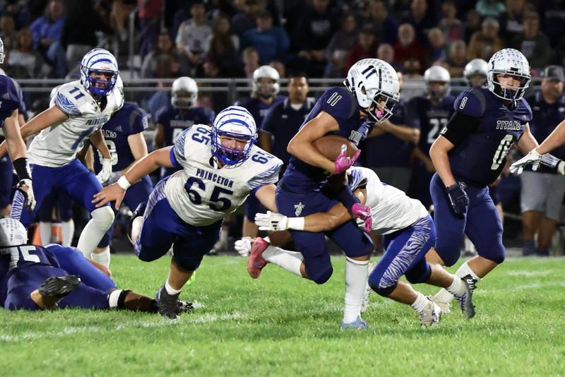 Princeton's Cade Odell (65) takes a dive at  Monmouth-Roseville's Payton Thompson, who's in the grips of another Tiger defender Friday at Monmouth.