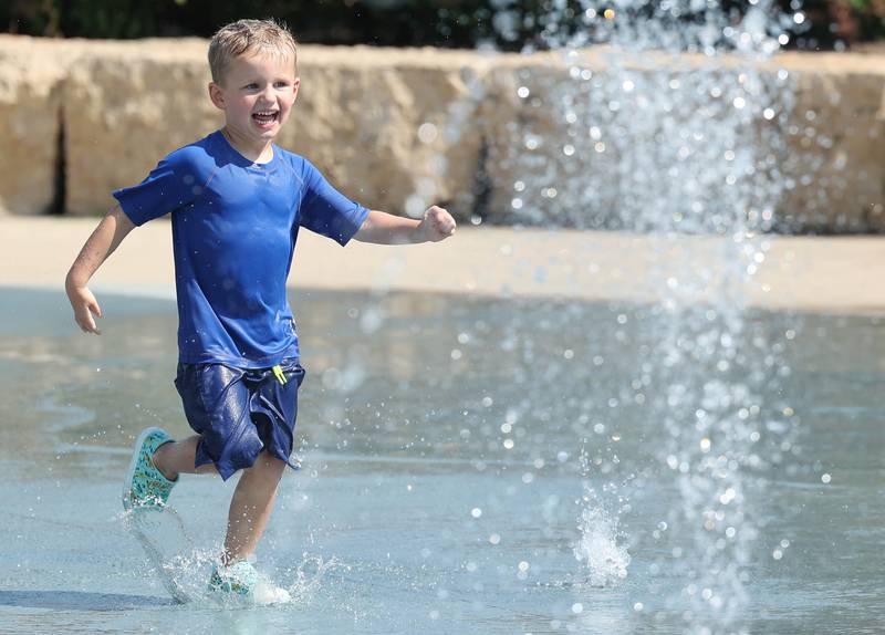 Boyd Swanson, 3, from Sycamore, races through the sprinklers Wednesday, Aug. 23, 2023, at the Sycamore Park District Splash Fountain splash pad. Temperatures climbed into the high 90’s Wednesday with more hot weather expected Thursday.