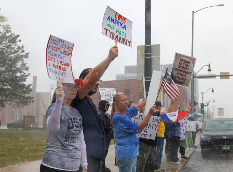 Protestors continue demonstrating as heavy rains passed through the area during the No Kings Rally on Saturday, Oct. 18, 2025, at the Kankakee County Courthouse.