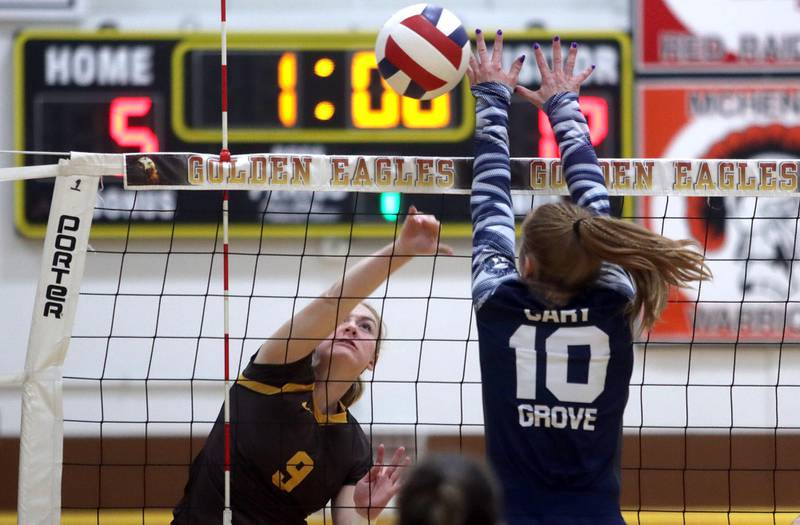 Jacobs’ Teagan Van Stone sends the ball over the net as Cary-Grove’s Erin Wadzinski blocks in girls volleyball at Algonquin Thursday evening.