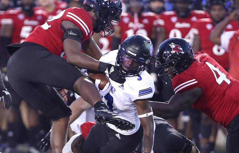 Northern Illinois Huskies defensive end Ivan Davis (left) and defensive end Raishein Thomas have Eastern Illinois Panthers running back Jaelin Benefield surrounded during their game Thursday, Sept. 1, 2022, in Huskie Stadium at NIU.
