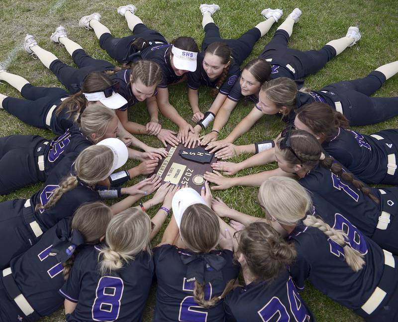 The Lady Serena Huskers gather in the outfield around their sectional plaque after defeating Marquette Friday at Serena.