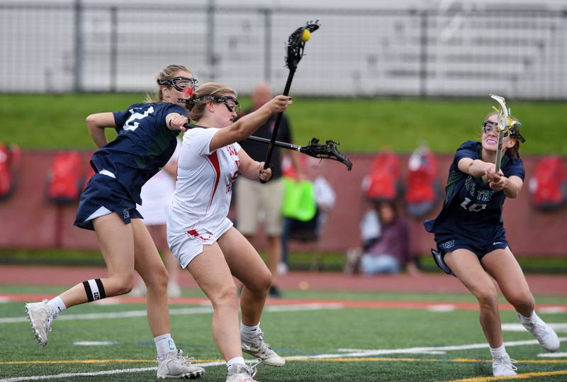 Joe Lewnard/jlewnard@dailyherald.com
Hinsdale Central’s Emily Brankin steps between New Trier’s Brooke Ross, left, and Ellie Bornhoeft and scores during the girls lacrosse IHSA championship game at Hinsdale Central High School Saturday.