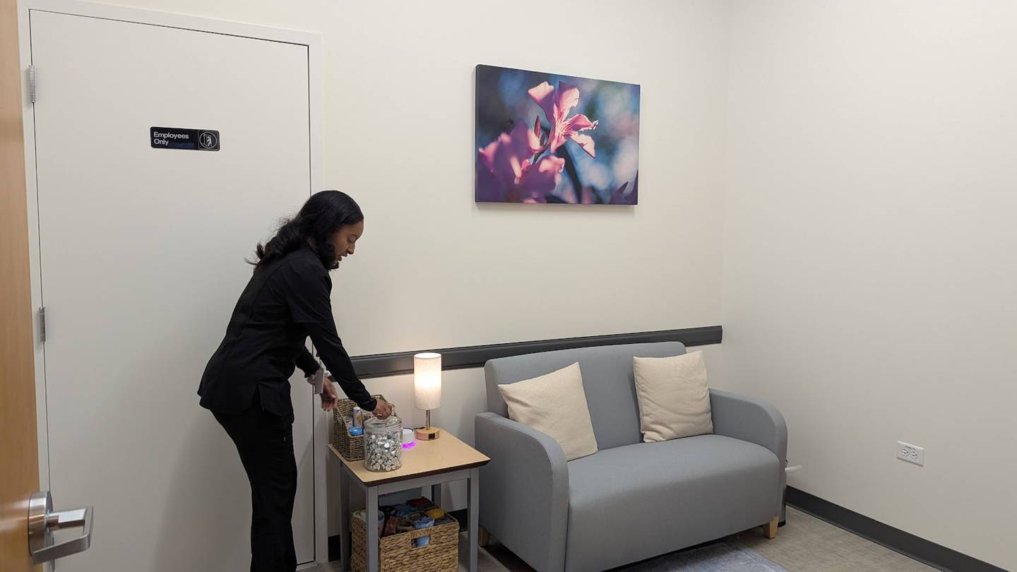 UrgentVet Joliet reserves a room with cozy furniture, calming colors, and snacks for pets and adults is reserved for instances when a decision to euthanize is made. Deja Finner, senior assistant at UrgentVet Joliet, draws attention to the snacks for people and pets at UrgentVet Joliet on Friday, Feb. 7, 2025.