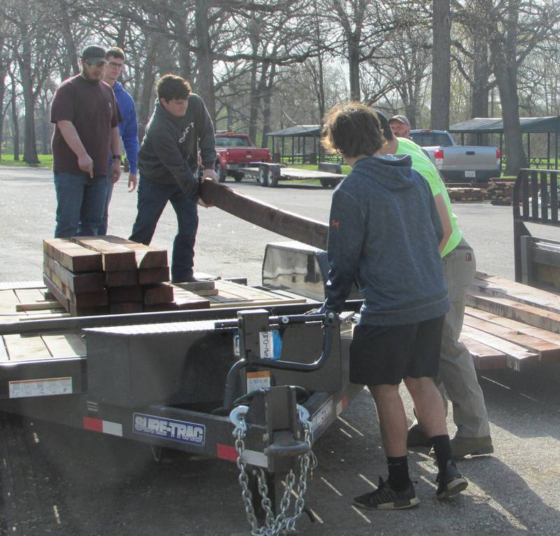 Streator High School students in David Taylor's woodworking class move wooden beams from a trailer onto a forklift Wednesday, April 19, 2023, as the class begins to construct a new picnic shelter at Marilla Park in Streator.