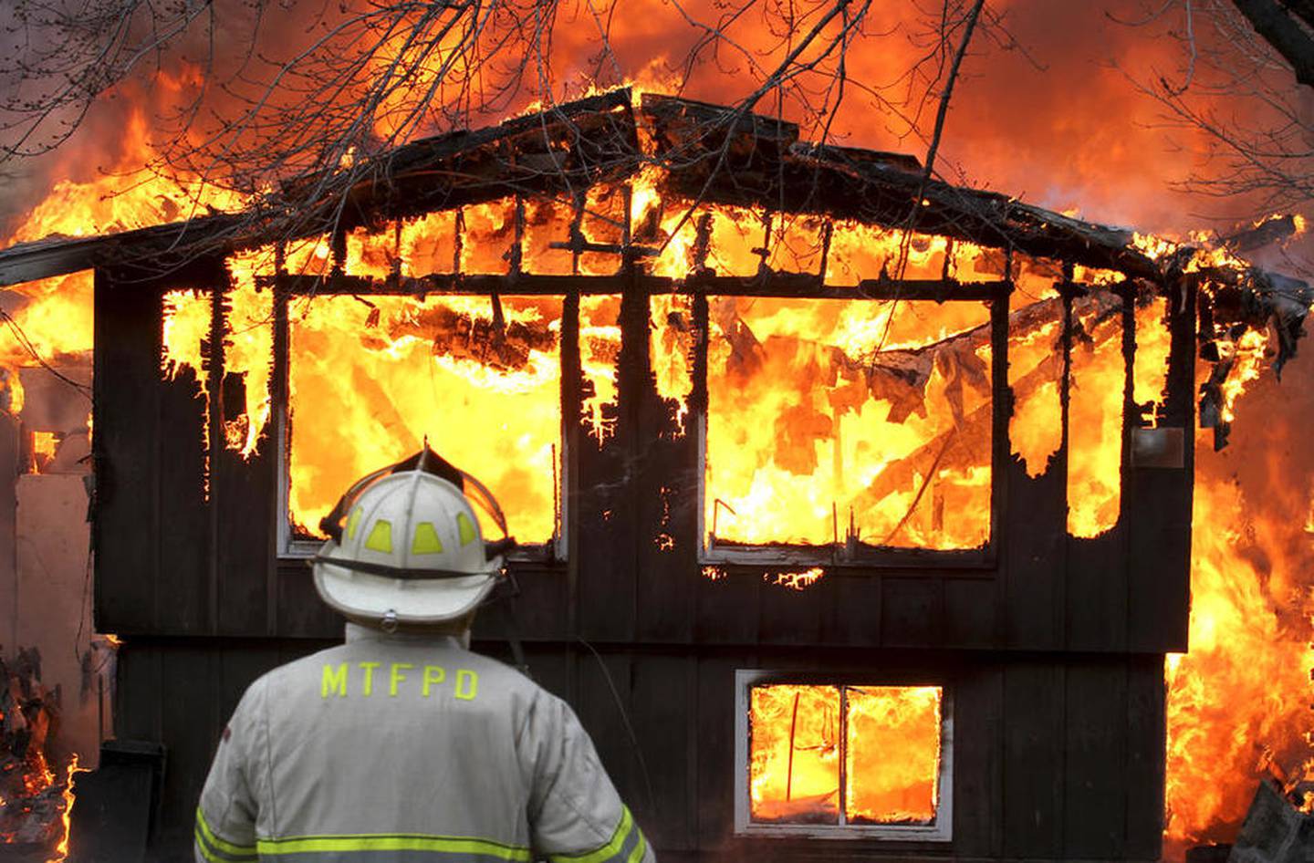 McHenry Township Fire Chief Tony Huemann watches March 20, 2011, as a fire engulfs a home after lightning struck the home.