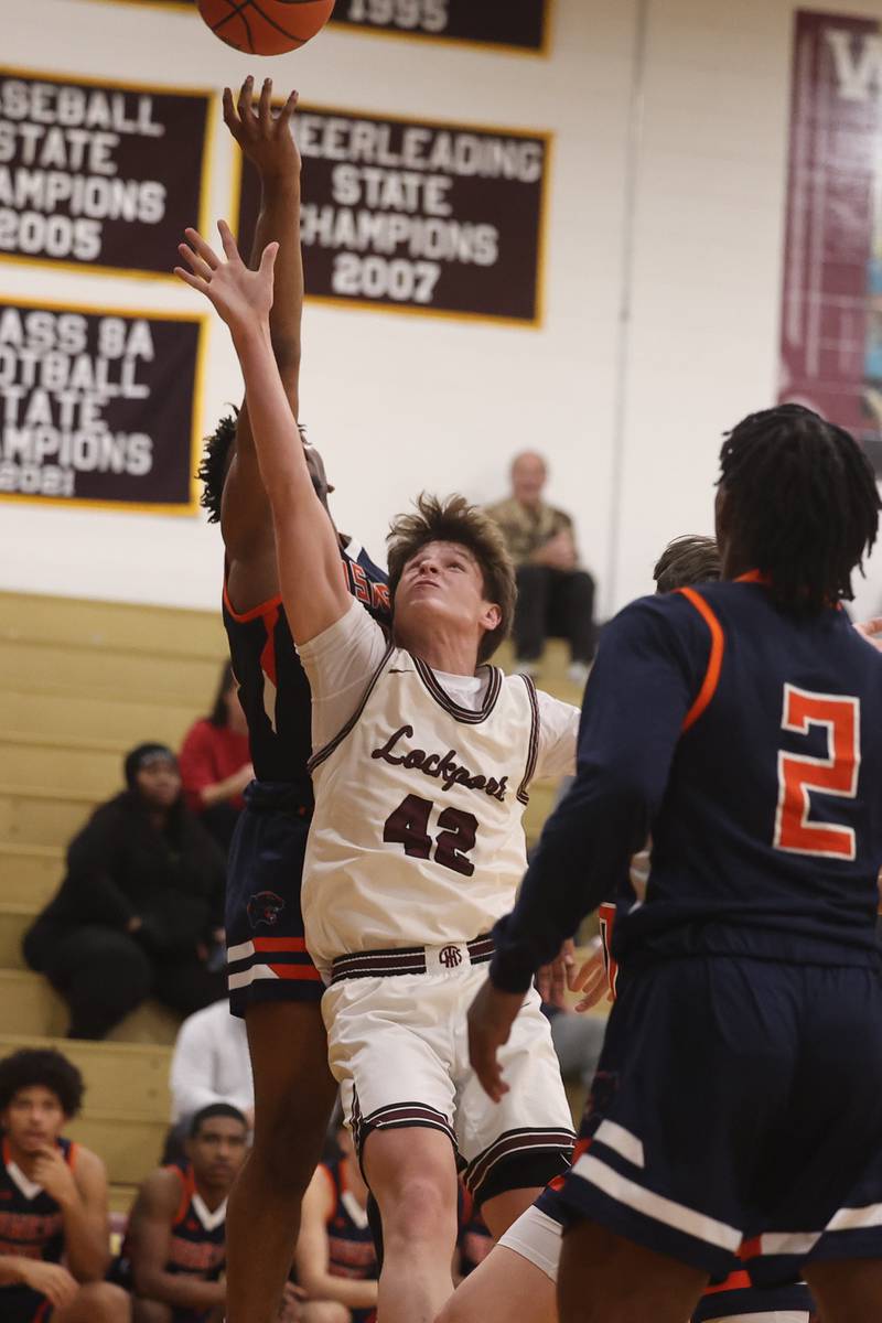 Lockport’s Caden Schoolcraft goes for the rebound against Oswego.