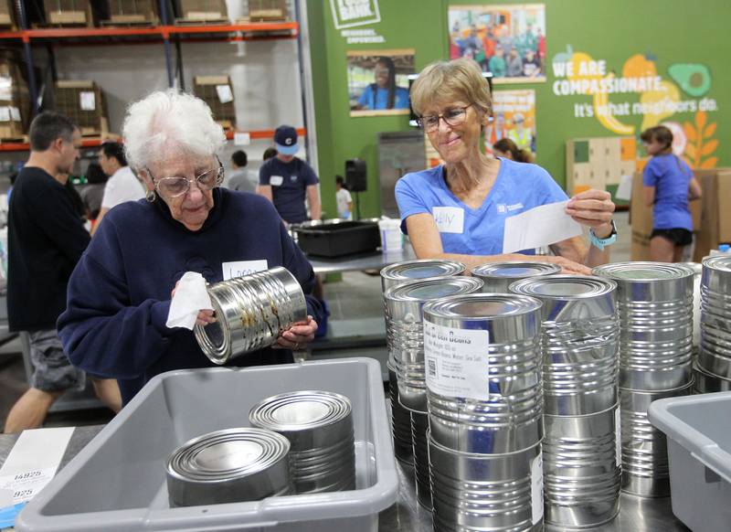 Lorna Bennett, of Mundelein works next to her daughter, Kelly, of Vernon Hills as they sort, clean and label big cans of cut green beans at the Northern Illinois Food Bank on August 19th in Lake Forest. The North Suburban Center recently celebrated it’s one-year anniversary at this location.  
Photo by Candace H. Johnson for Shaw Local News Network