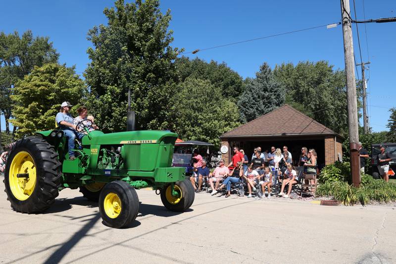 A family drives a tractor along the Grand Parade route during the 104th annual Herscher Labor Day Celebration on Monday, Sept. 1, 2025.