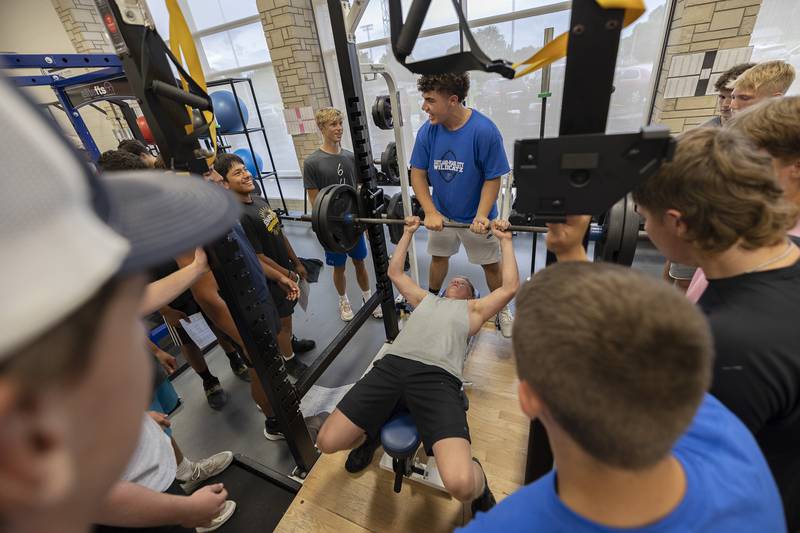 With the encouragement of his teammates, EPC player Jared Runkle prepares to bench Monday, August 14, 2023 at Eastland High School.