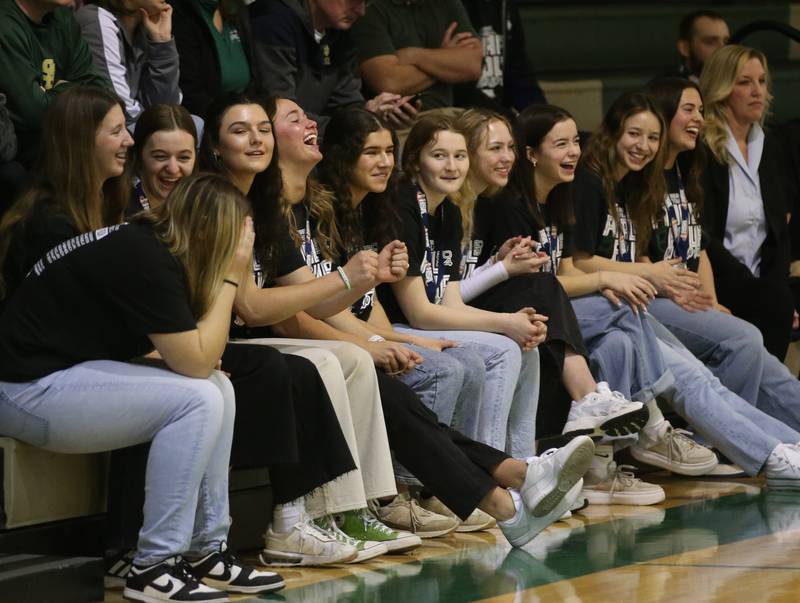 Members of the St. Bede girls basketball team react as they watch a video slideshow of their season during a celebration ceremony on Tuesday, March 5, 2024 in Abbot Vincent Gymnasium.