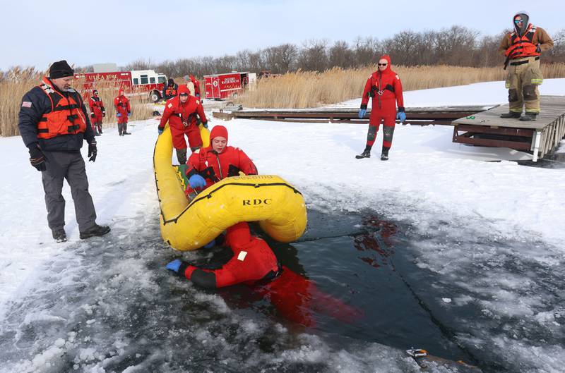 Utica, Oglesby and Tonica firefighters conduct an ice-rescue training drill as Oglesby fire chief Steve Maltas (left) watches while using an inflatable ice raft on a private pond on Sunday, Feb. 1, 2026 south of Utica.