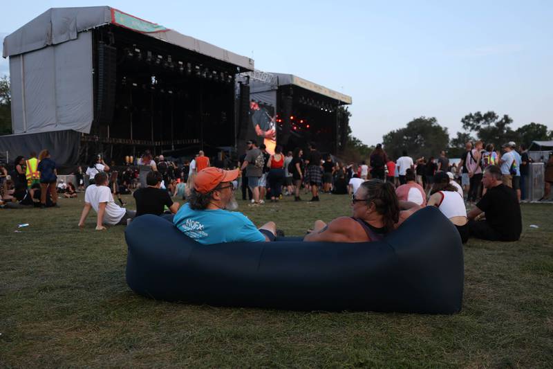 Phil Snow and Laura Murph, from the northwest suburbs, sit on an inflatable lounger to take in the live music on day two of Riot Fest. Saturday, Sept. 18, 2022, in Chicago.