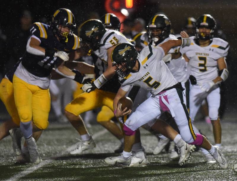 Glenbrook North's Jack Philbin carries the ball as Glenbrook South’s Jacque Gariepy (11) gets ready to make a tackle during Friday’s game in Glenview.