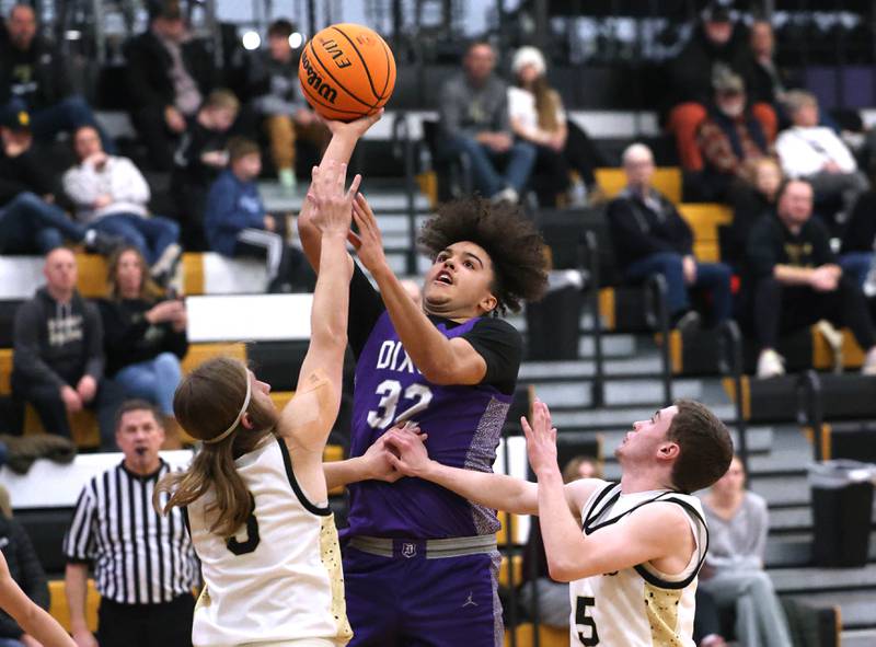Dixon’s Darius Harrington goes to the basket between Sycamore's Carter McCormick (right) and Preston Picolotti during their game Tuesday, Jan. 14, 2025, at Sycamore High School.