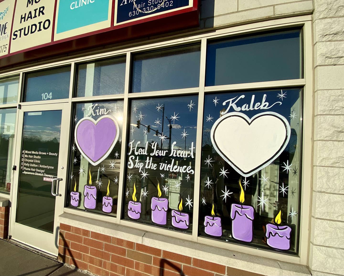 A memorial painting with the names "Kim" and "Kaleb" adorns a window on Wednesday, Dec. 11, 2024, outside Chrystal Clinic, 437 W. State St., in downtown Sycamore. Kaleb McCall, 17, was stabbed to death on Sept. 7, 2023. Kimberly Hurley, 56, was found shot to death outside her home on Nov. 22, 2024. The painting calls for an end to violence in the community.