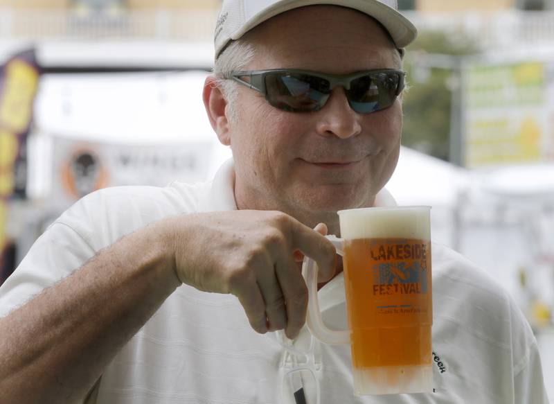 Craig Kingston shows off his vintage beer mug from a past Lakeside Festval during this years festival on Friday, June 30, 2023, at the Dole and Lakeside Arts Park in Crystal Lake.