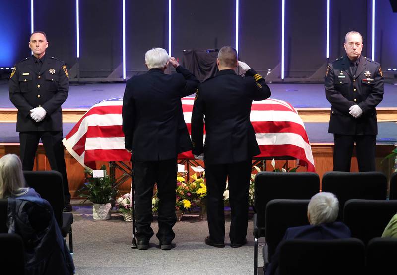 Former DeKalb County Sheriff Wilbur Scott, (left) and current DeKalb County Sheriff Andy Sullivan salute the casket of Roger Scott, former sheriff and younger brother of Wilbur, during visitation Thursday, March 6, 2025, at Bethany Road Bible Church in DeKalb. Roger Scott, who was the county sheriff for more than 30 years, died on Feb. 23 at the age of 78.